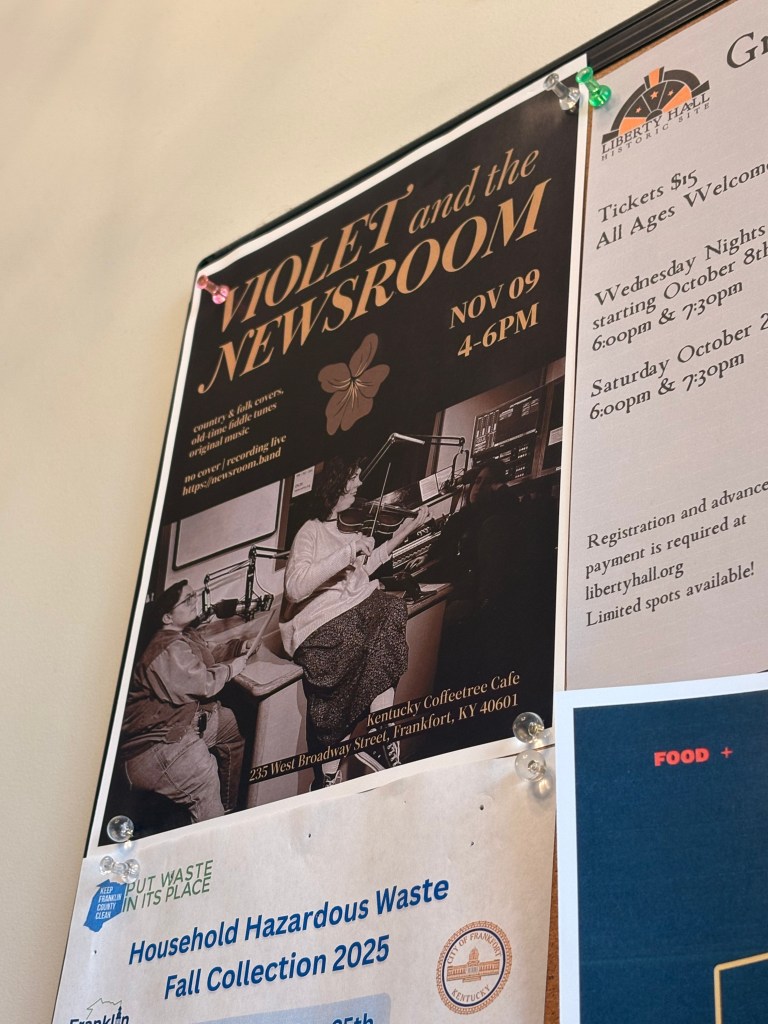 A poster on a bulletin board. It's for Violet and the Newsroom, with the same information as is on the previous digital poster for the Coffeetree.
