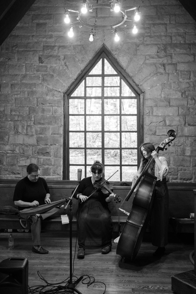 Black-and-white photo of Clay, Violet, and Anabel playing inside The Chapel at Pine Mountain Settlement School. (Same photo as the first image in this post, except it's vertical rather than the horizontal crop.)