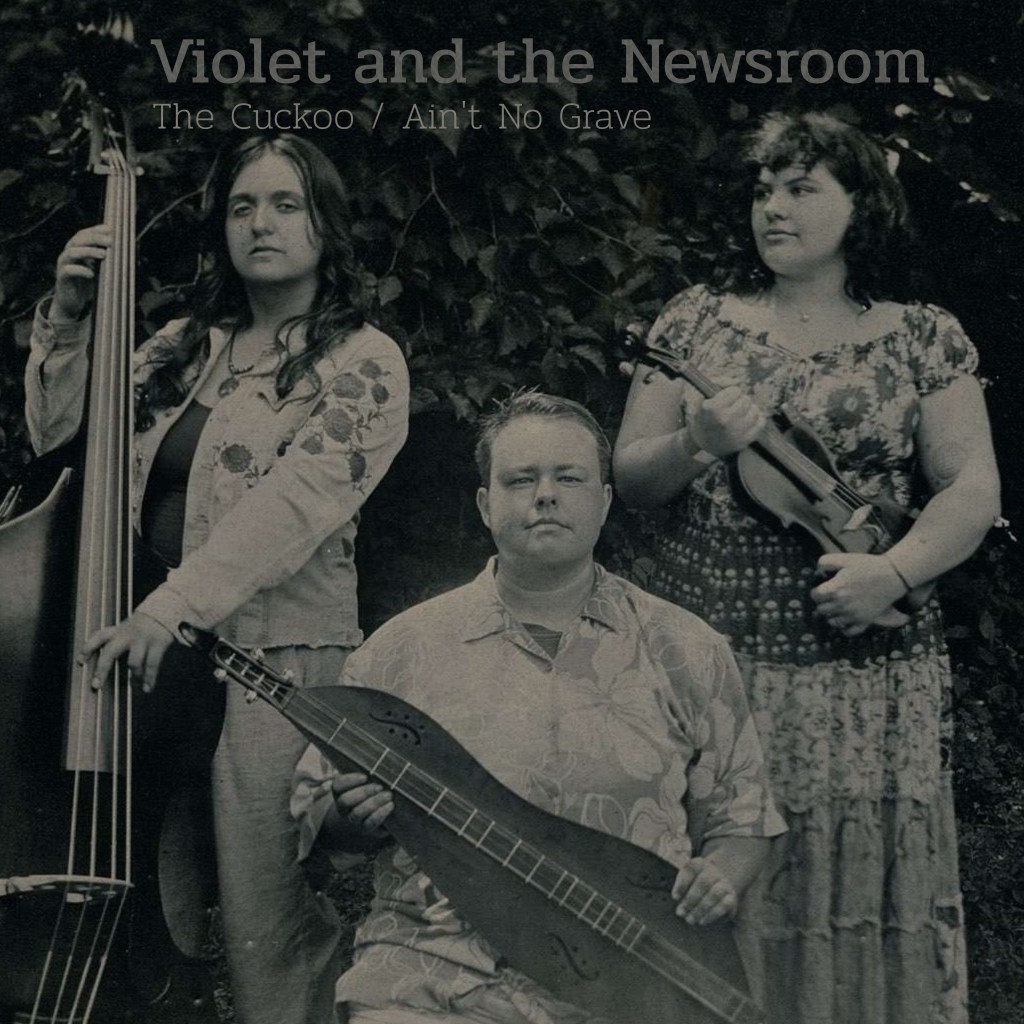 Tintype photo of the three members of Violet and the Newsroom. Anabel stands with an upright bass, Clay sits with a mountain dulcimer, and Violet stands with a fiddle. Anabel and Clay look directly at the camera with reserved, neutral expressions. Violet wears a neutral expression, but looks at her bandmates rather than the camera. Text at the top of the image reads "Violet and the Newsroom The Cuckoo / Ain't No Grave"